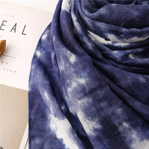 Dettaglio ravvicinato della sciarpa in cotone e lino tie-dye blu e bianca con trama