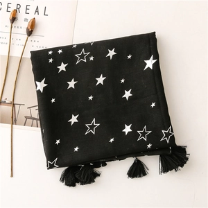 Detail of black cotton linen scarf with silver star prints and fine fringe tassels