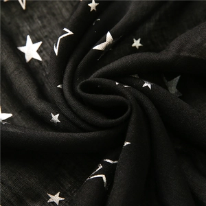 Black cotton linen scarf with silver star pattern displayed in a spiral fold style