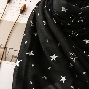 Close-up of soft black cotton linen scarf featuring metallic silver star patterns