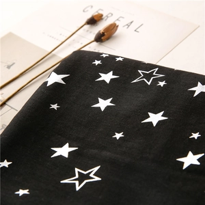 Detail of black cotton linen fabric with silver star patterns and minimalist magazines