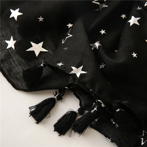Macro detail of black cotton linen scarf with silver star pattern and elegant fringe