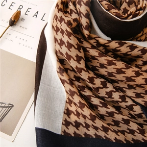 Détail d'une écharpe douce à motif pied-de-poule avec texture tissée beige et café