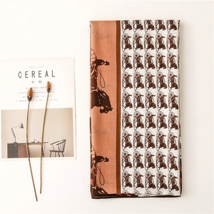 Detailed flat lay of a carriage print scarf with magazine and decorative plant props