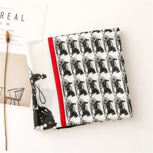 Detail of horse carriage pattern on white cotton linen scarf with red border