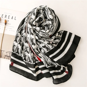Detail of soft scarf featuring retro horse carriage prints and artistic styling