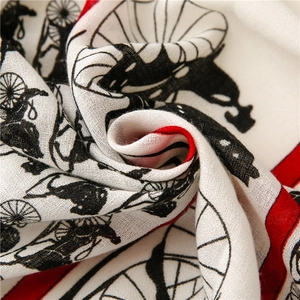 Macro shot of cotton linen scarf showing black carriage prints and red borders
