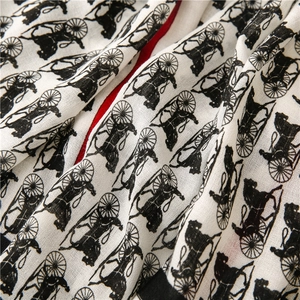 Close-up of horse carriage print scarf with red and black border details