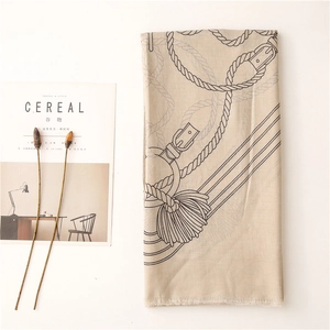 Flat lay di una sciarpa di cotone beige con stampa cintura, decorata con rivista e fiori secchi