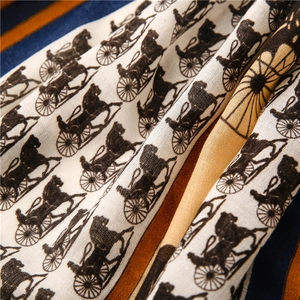 Detail of vintage carriage print on striped cotton-linen scarf with soft fabric texture