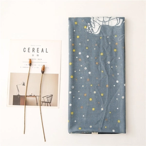 Blue floral scarf with white carriage pattern laid with dried flowers and magazine