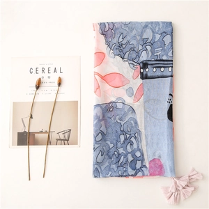 Elegant pink and blue printed scarf with fringe tassels shown in a minimalist flat lay