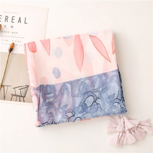 Detail of color-block cotton scarf with ink floral prints and soft pink tassels