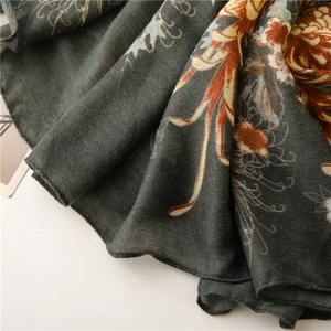 Gros plan sur écharpe gris foncé aux motifs floraux vintage orange et bleu sur tissu sergé