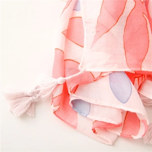 Detailed shot of lightweight floral scarf showing soft tassel charms and premium fabric