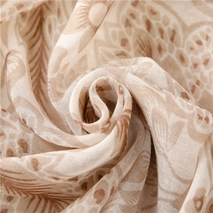 Soft voile scarf with khaki floral print shown in a dynamic elegant swirl pattern