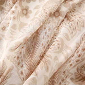 Close-up of lightweight voile fabric with vintage khaki floral print and soft texture