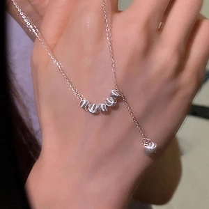 Gros plan détaillé d'un collier minimaliste avec cinq perles de transfert en argent givré