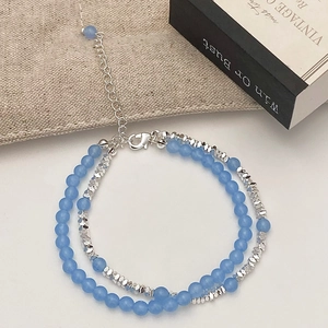 Detail of light blue natural stone beaded bracelet with silver lobster clasp and chain