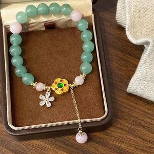 Bracelet chinois perles de pierre verte naturelle et détails floraux dorés élégants