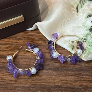 Luxurious purple crystal and pearl wire-wrapped C-shape earrings on a jewelry box
