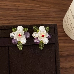 Elegant floral stud earrings with purple crystals, pearls and green leaf accents