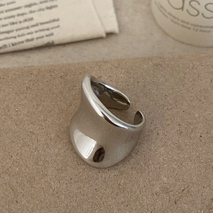 Minimalist wide open silver ring with polished mirror finish on rustic background