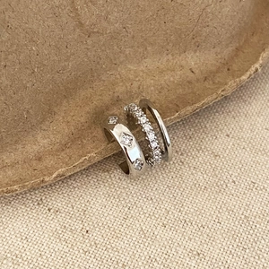 Close-up of three-piece silver ear cuff set with zirconia inlay on craft card