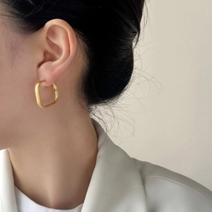 Boucles d'oreilles créoles carrées géométriques dorées avec une finition en métal brossé