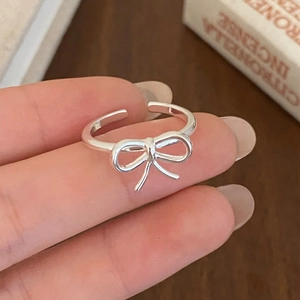 Detailed close-up of a silver bow knot open ring with a polished minimalist design