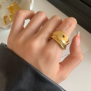 Bague large dorée au design ondulé moderne avec une finition métallique brillante
