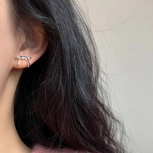 Minimalist silver bow earrings in S925 sterling silver worn by a model for a stylish look