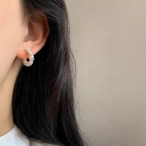 Chic silver hoop earrings with a textured crushed bead design shown on a female model