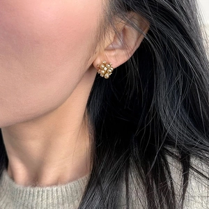 Boucles d'oreilles fleuries avec perles dorées et zircons portées par le modèle