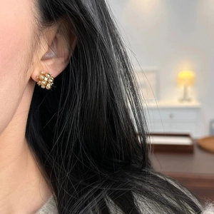 Gros plan de boucles d'oreilles élégantes en perles champagne et zircons sur modèle
