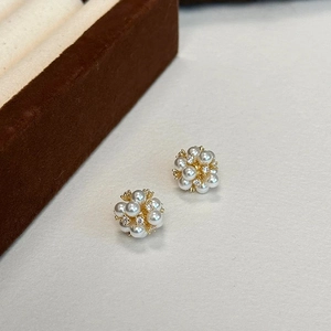 Vue macro de boucles d'oreilles en grappes de perles avec oxydes de zirconium et base dorée