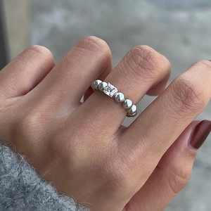 Minimalist silver beaded ring featuring a square cut white zircon stone on a woman's finger