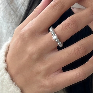 Minimalist silver beaded ring with a square zircon center stone on a female hand