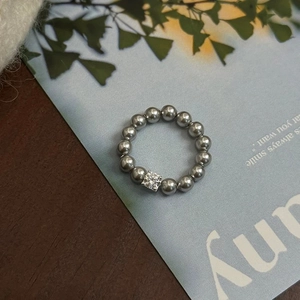 Detail of beaded pearl ring with a sparkling square zircon on a decorative card