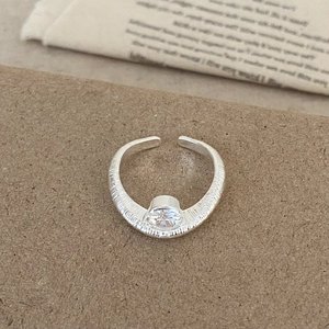 Dettaglio di un anello in argento strutturato con un brillante zircone centrale