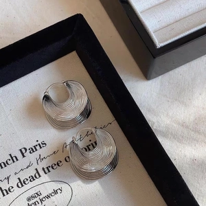 Detailed view of silver semicircular earrings with textured radial layers in ins-style