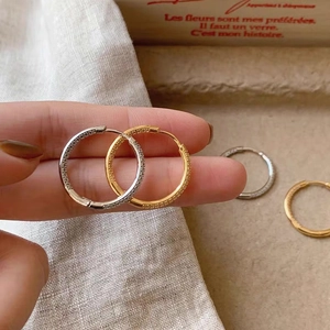 Detailed view of elegant gold and silver hoop earrings with fine cubic zirconia inlay