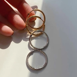 Detailed view of gold and silver hoop earrings featuring micro-pave crystal diamonds