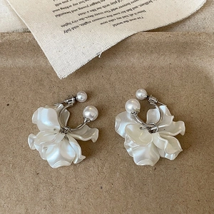 Elegant pearl petal earrings with gold accents on a rustic vintage background