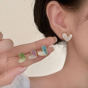 Elegant gold-framed heart enamel stud earrings in four colors worn by a model