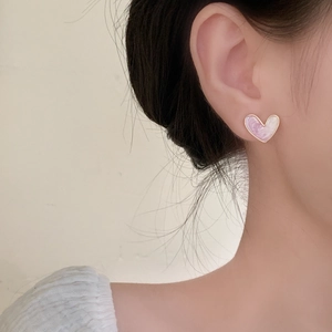 Elegant lavender marble heart stud earrings with gold trim worn by a female model