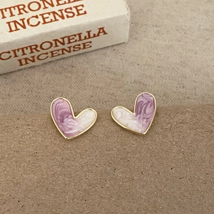 Detail of sweet heart-shaped stud earrings with purple marble enamel and gold trim