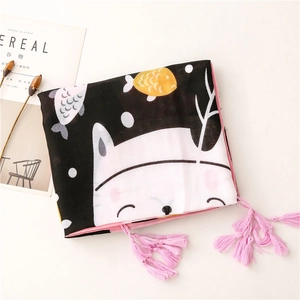 Close-up of thin scarf with cute cartoon cat prints and pink tassel edges on white background
