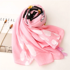 Detailed close-up of pink cat-themed scarf showing heart prints and tassel edges
