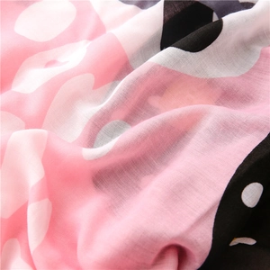 Close-up of soft pink and white woven fabric with playful polka dot patterns on scarf